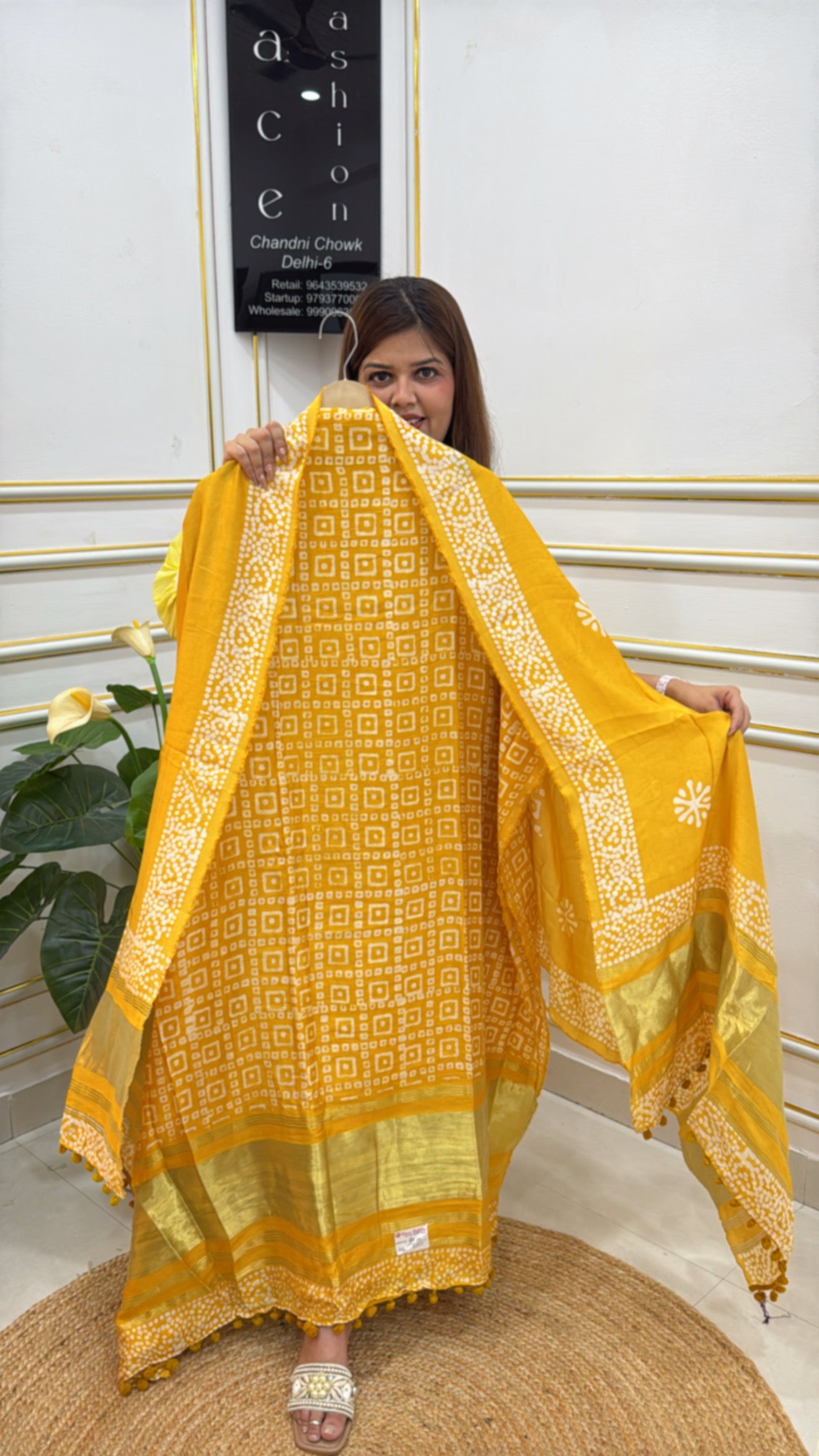 Woman showcasing a vibrant yellow premium batik suit with intricate patterns and elegant detailing